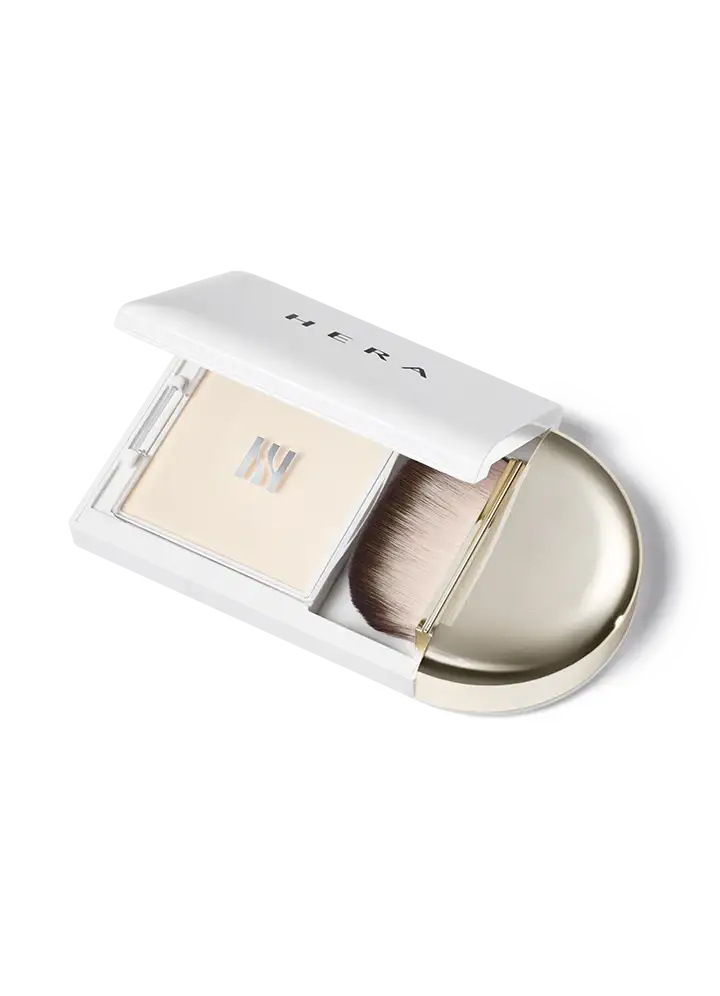 Hera loose powder compact with brush, sleek white design for radiant skin finish