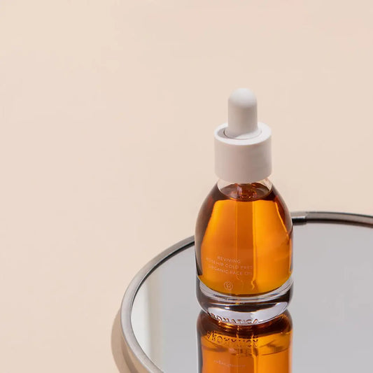 Reviving rosehip cold pressed organic face oil in glass dropper bottle on mirrored surface