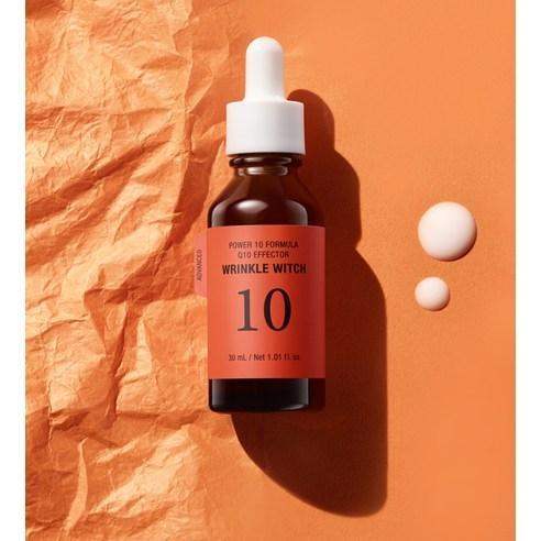 Wrinkle Witch Power 10 Formula serum bottle with dropper on warm orange textured background, skincare essence drops nearby